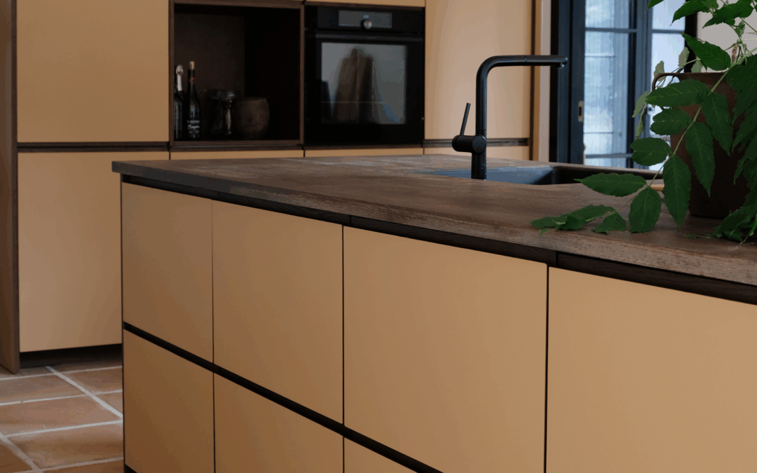 Moderne beige køkken med træbordplade og sorte detaljer som inspiration til dig der undersøger hvad koster et IKEA køkken.
