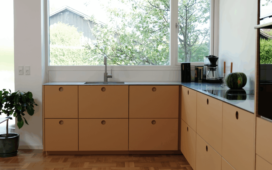 Moderne beige køkken med store vinduer og mørk bordplade som inspiration til dig der vil vide hvad koster et køkken.