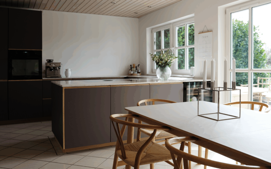 Elegant køkken med brune fronter, lys bordplade og spiseplads – et eksempel på moderne stil og prisniveau, når man overvejer, hvad koster renovering af køkken.