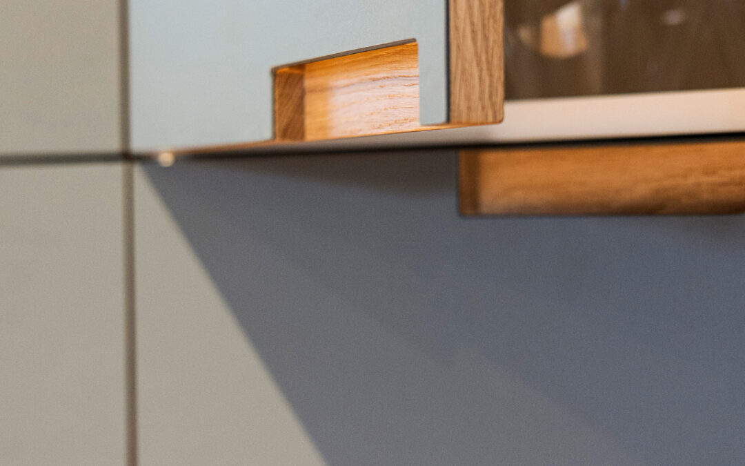 Detalje af køkkenlåge i træ og laminat med elegant udskåret greb – eksempel på materialer der viser, hvilke køkkenlåger holder bedst.