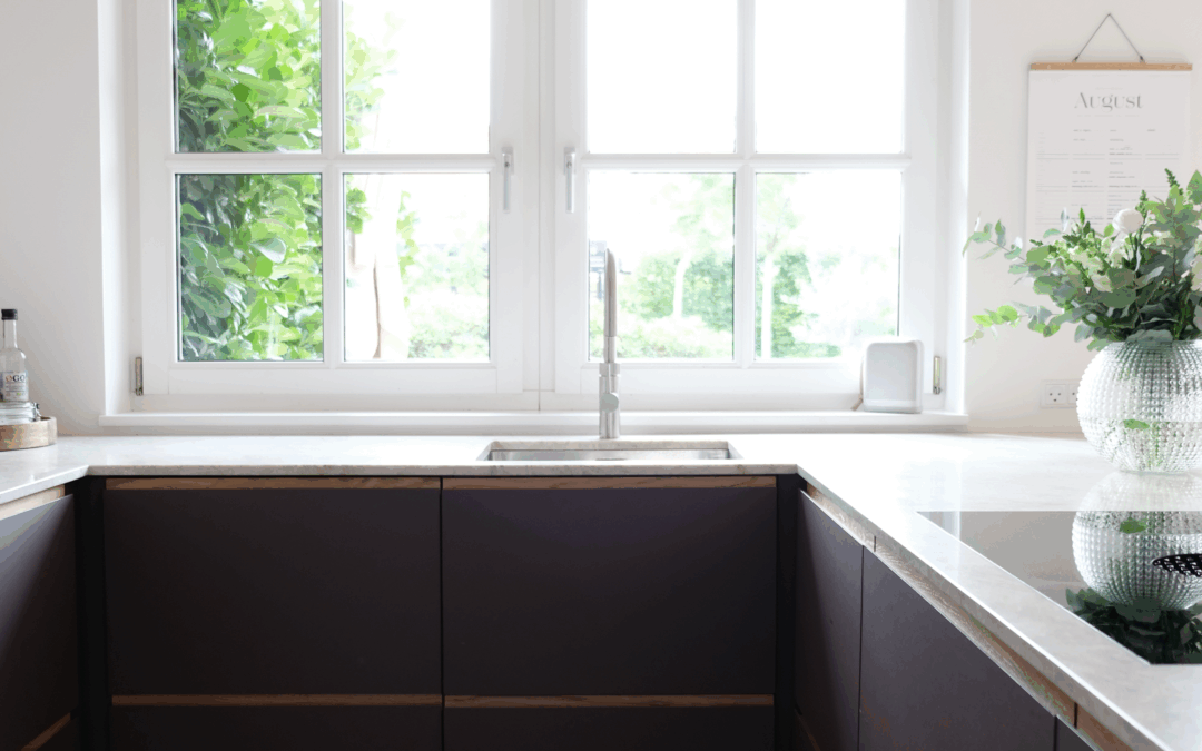 Moderne køkken med mørke fronter og lys bordplade – eksempel på resultatet efter professionel montering, når man overvejer, hvordan man monterer et køkken.