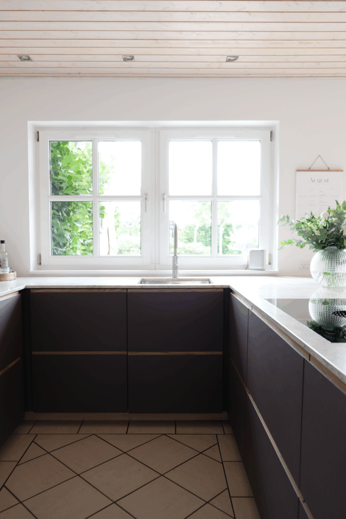 Moderne køkken med mørke fronter og lys bordplade – eksempel på resultatet efter professionel montering, når man overvejer, hvordan man monterer et køkken.