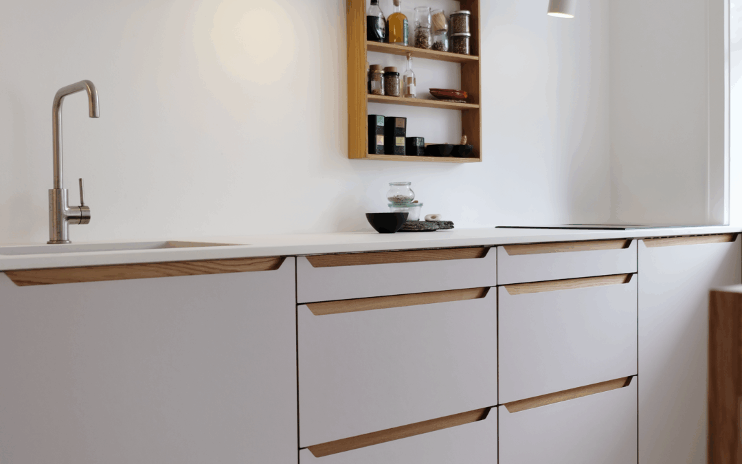 Lyst køkken med integrerede trægreb og åben hylde til krydderier – eksempel på design og finish, når man undersøger, hvor lang tid tager det at sætte et køkken op.