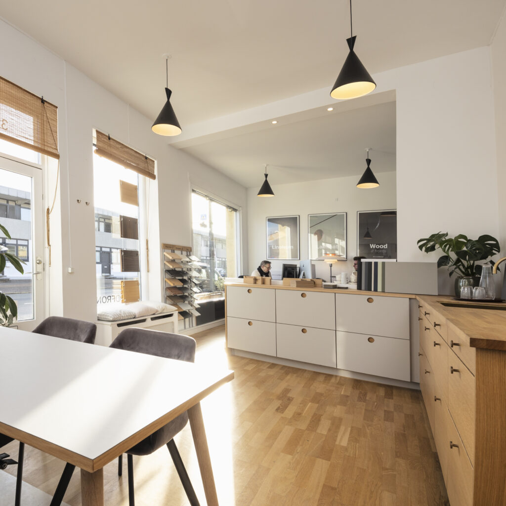 Lyst showroom med moderne køkkendesign og materialevalg – viser idéer til hvordan man fornyer sit køkken med personlig stil og kvalitet.