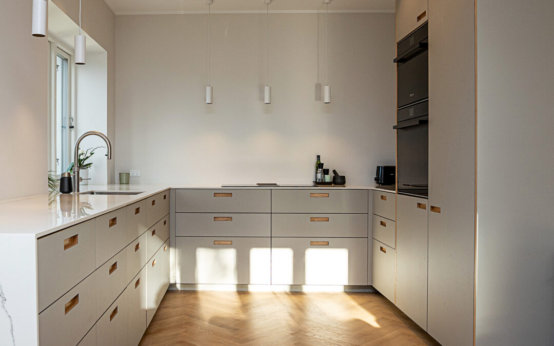 Moderne gråt køkken med indbyggede skabe og trægulv – viser resultatet af korrekt opmåling af køkken før montering.