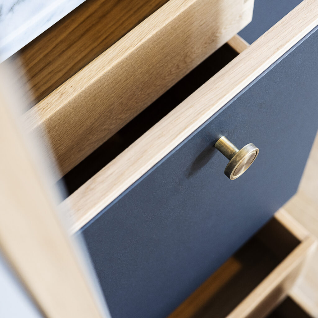 Nærbillede af køkkenskuffe med mørk laminatfront og messinggreb – viser overfladetypen, der ofte får spørgsmålet: kan man male laminat køkkenlåger?