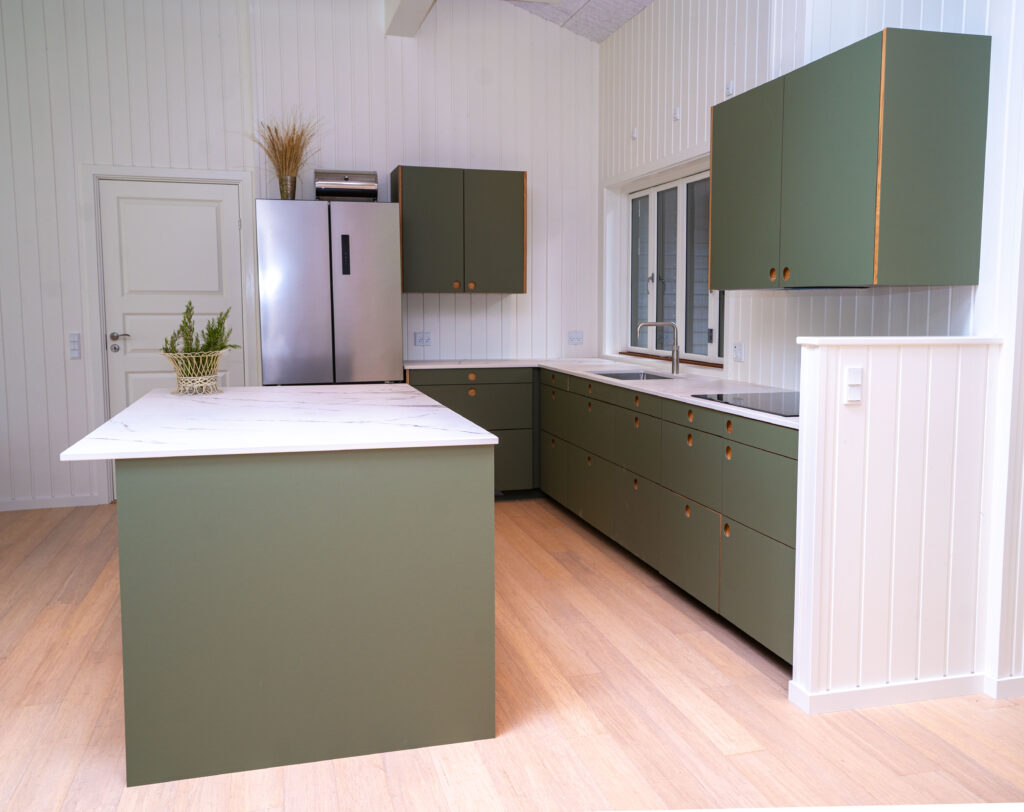 Moderne grønt køkken med hvide vægge, lyse trægulve og marmor bordplade – perfekt som grønt køkken inspiration til et nordisk hjem.