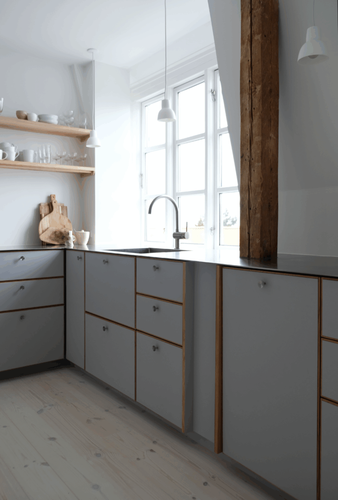 Lyst og elegant gråt køkken med synlige bjælker, åbne hylder og naturlige materialer – ideel gråt køkken inspiration til nordisk indretning.