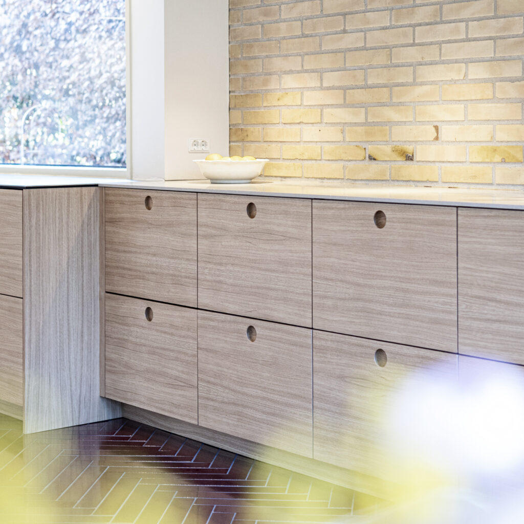 Moderne køkken med lys laminatbordplade og enkle detaljer – perfekt eksempel i forbindelse med rensning af laminatbordplade og vedligeholdelse af overflader.