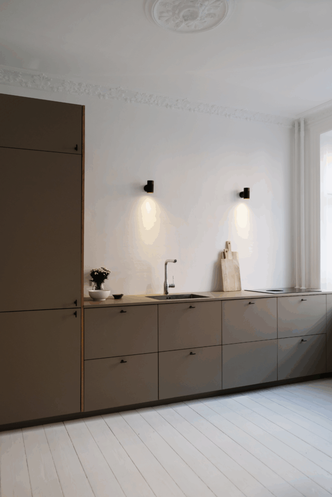 Stilrent køkken med laminatbordplade og varme træelementer, hvor korrekt rensning af laminatbordplade sikrer et holdbart og pænt resultat.