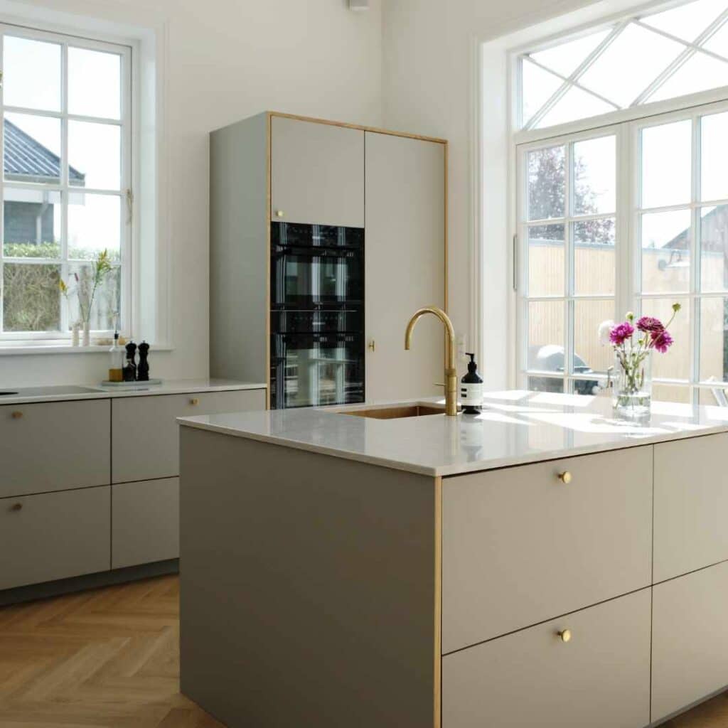 Lyst moderne køkken efter renovering – elegant resultat af at forny gammelt køkken.