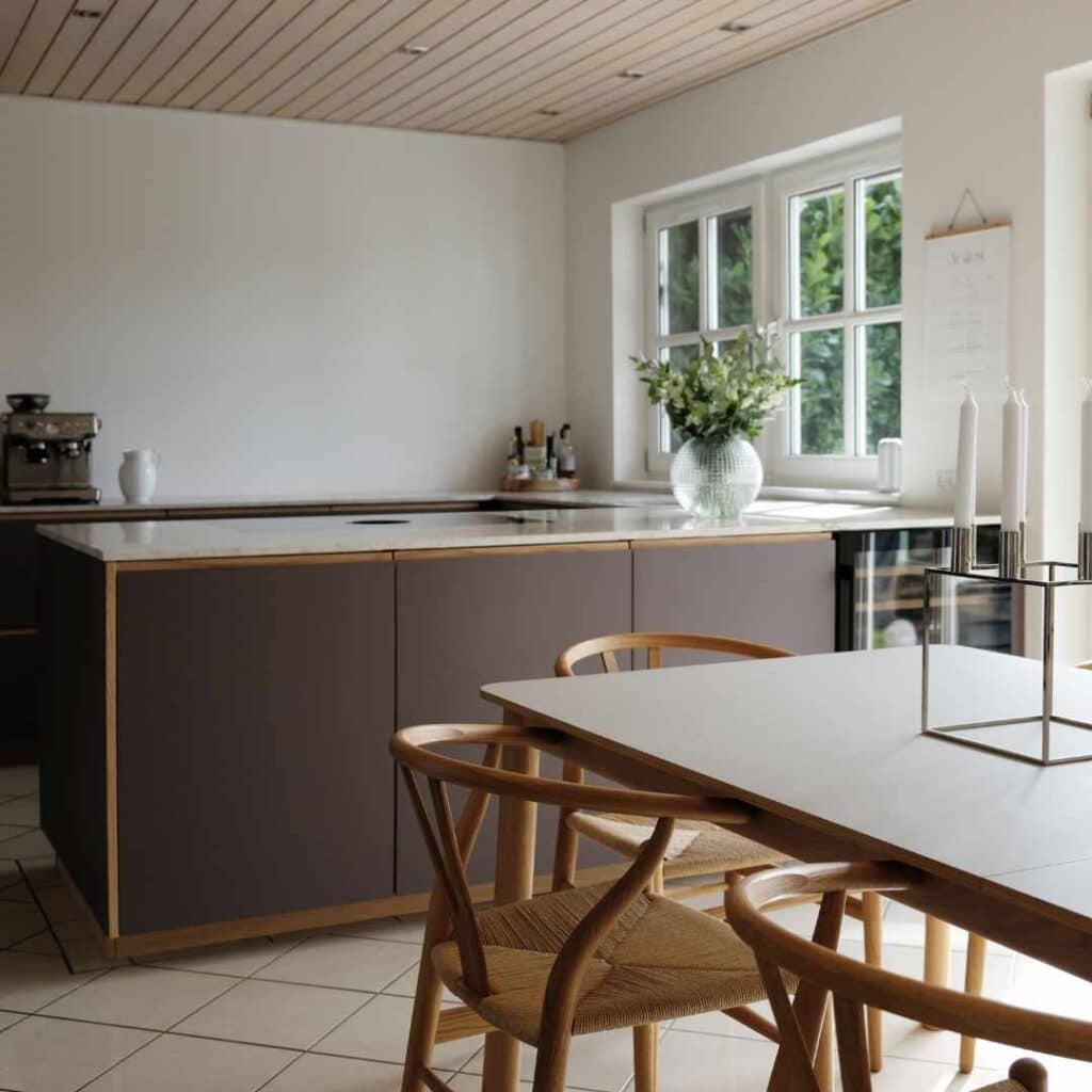 Mørkt køkken i brune nuancer med minimalistisk design, trædetaljer og et varmt, eksklusivt udtryk.