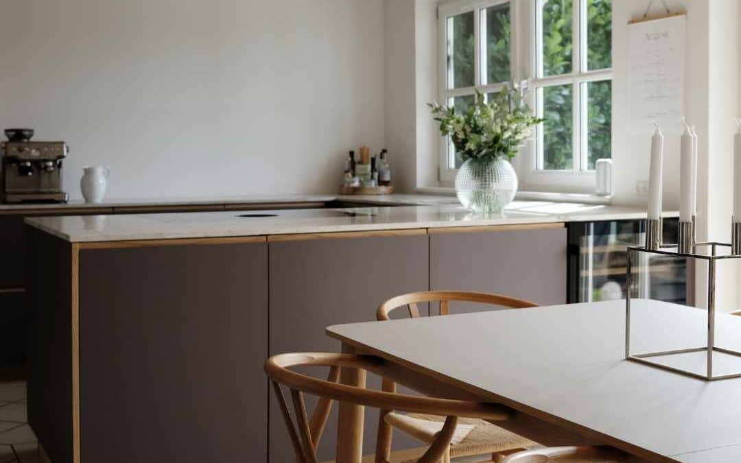 Mørkt køkken i brune nuancer med minimalistisk design, trædetaljer og et varmt, eksklusivt udtryk.