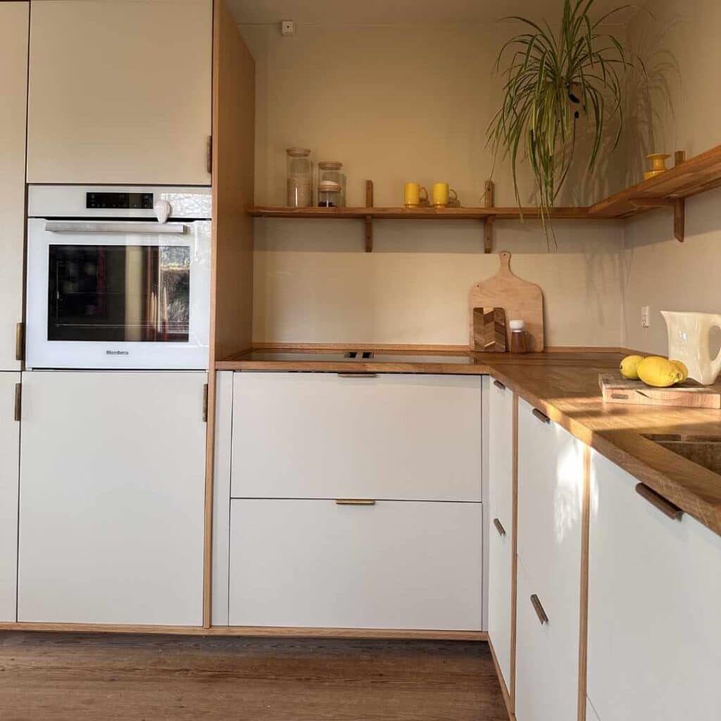 Klassisk lyst køkken med lyse fronter, træbordplade og åbne hylder i et tidløst og funktionelt design.