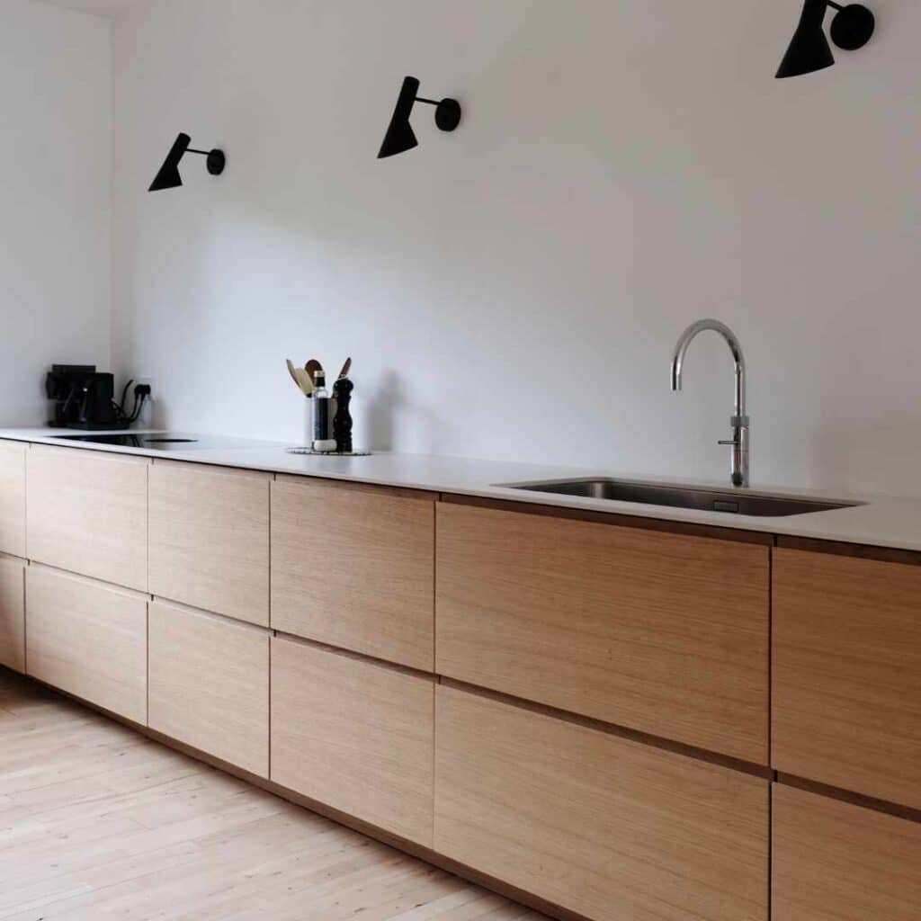 Moderne køkken med nye skabslåger i egetræ og minimalistisk design med grebsfrie fronter.